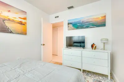 a bedroom with a bed and a tv on a wall at Walk to 2026 FIFA World Cup! Home with Spacious Yard in Miami