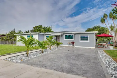 a white house with palm trees in front of it at Walk to 2026 FIFA World Cup! Home with Spacious Yard in Miami