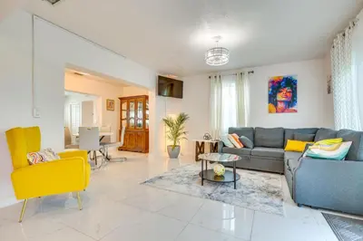 a living room with a blue couch and yellow chairs at Walk to 2026 FIFA World Cup! Home with Spacious Yard in Miami