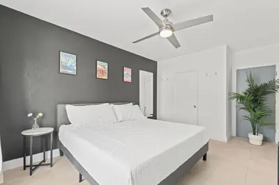 a bedroom with a white bed and a ceiling fan at Harding Apartments by Andes STR in Miami Beach