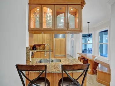 a kitchen with a sink and a counter with two chairs at Casa Fina Miami Near Beaches