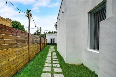 a walkway between a fence and a house at Stylish Miami Getaway in Miami