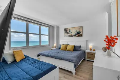 two beds in a bedroom with a view of the ocean at Elara Beachfront 2 Bedrooms Direct OceanView with Parking in Miami Beach