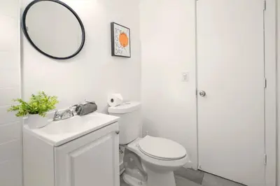 a white bathroom with a toilet and a mirror at Coastal Studio Stay Near the Beach in Miami