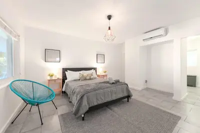 a bedroom with a bed and a blue chair at Coastal Studio Stay Near the Beach in Miami