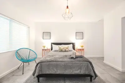 a bedroom with a bed and a blue chair at Coastal Studio Stay Near the Beach in Miami