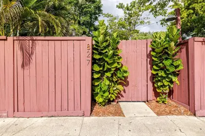 a red fence with a bunch of bananas on it at Your Modern South Florida Oasis Comfy and Central in Fort Lauderdale