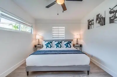 a bedroom with a bed with blue pillows at Friendly Fox Luxury Pool & Spa House Near Downtown & Beach in Fort Lauderdale