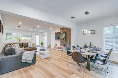 a living room with a couch and a table with chairs at Friendly Fox Luxury Pool & Spa House Near Downtown & Beach in Fort Lauderdale