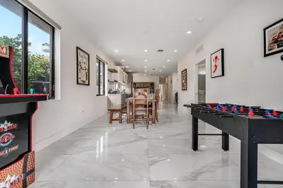 a living room with a table and a game room at Fox Sonata Downtown Pool House in Fort Lauderdale