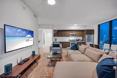 a living room with a couch and a tv on a wall at High Floor Unit Heart Of Miami with pool and gym in Miami