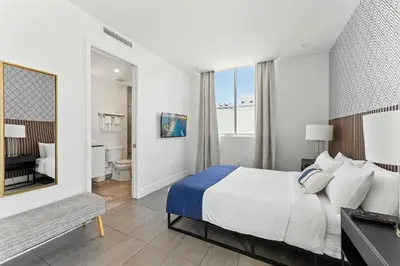 a hotel room with a bed and a bathroom at South Beach Sleek 2BR Getaway in Miami Beach