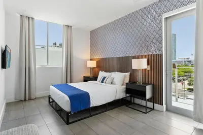 a bedroom with a bed and a large window at South Beach Stylish 2BR Retreat in Miami Beach