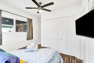 a bedroom with a bed and a flat screen tv at Trendy 4 Bedroom Pool Home Minutes from the Beach in Hollywood