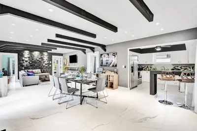 a kitchen and living room with a table and chairs at Trendy 4 Bedroom Pool Home Minutes from the Beach in Hollywood