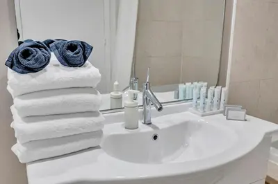 a bathroom with a sink with towels and a mirror at 48th Floor ocean View Brickell in Miami