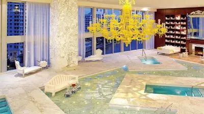 a large living room with a chandelier and a pool at 40th floor High Ceilings unit at icon brickell in Miami