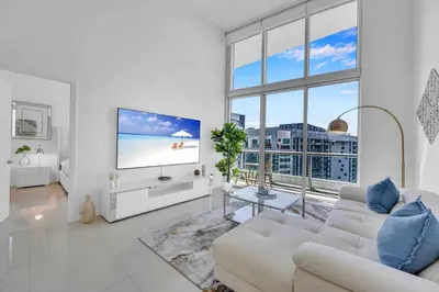 a living room with a white couch and a flat screen tv at 40th floor High Ceilings unit at icon brickell in Miami