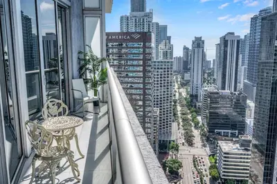 a balcony with a table and chairs and a city at 40th floor High Ceilings unit at icon brickell in Miami