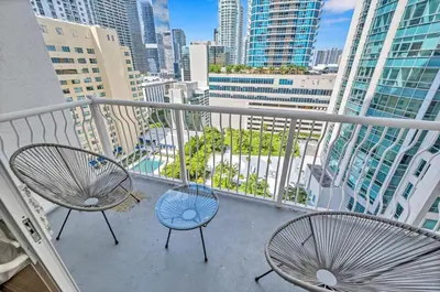two chairs on a balcony with a view of a city at Superb private unit with amenities and parking in Miami