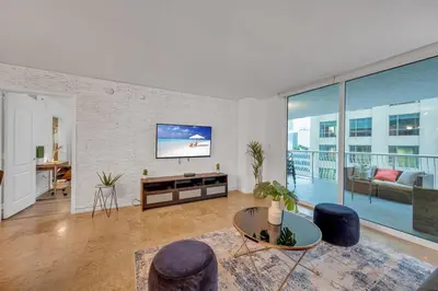 a living room with a tv and a couch and a table at Amazing unit location with amenities & parking in Miami
