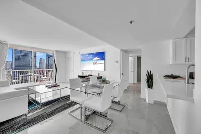 a white living room with a table and chairs at Luxurious 34th floor Ocean view Private Unit in Miami