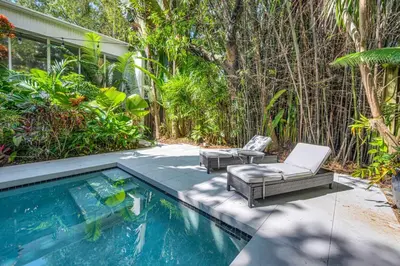 a swimming pool with two lounge chairs and a swimming pool at Wonderful Tropical Pool House Miami Coconut Grove in Miami