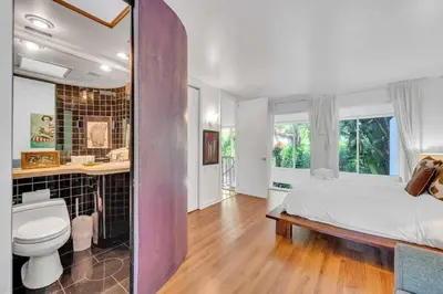 a bedroom with a bed and a bathroom with a toilet at Wonderful Tropical Pool House Miami Coconut Grove in Miami