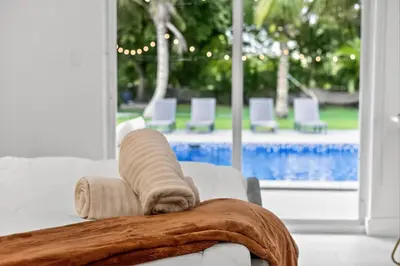 a pile of towels sitting on top of a couch at Luxe 4BR Miami Pool-Near Airport-Games-Backyard in Miami
