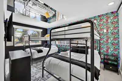 a room with three bunk beds and a mural at Luxe 4BR Miami Pool-Near Airport-Games-Backyard in Miami