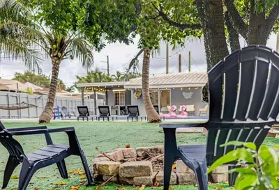 two black chairs and a table in front of a house at Luxe 4BR Miami Pool-Near Airport-Games-Backyard in Miami