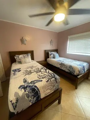 a bedroom with two beds and a ceiling fan at Modern Beachfront Suite at Hollywood Broadwalk in Hollywood