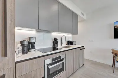 a kitchen with a sink and a stove top oven at Stylish Miami Condo with Beach Access at 72 Park in Miami Beach