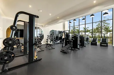 a gym with several treadmills and weights at Stylish Miami Condo with Beach Access at 72 Park in Miami Beach