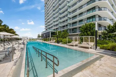 a large swimming pool in front of a building at Stylish Miami Condo with Beach Access at 72 Park in Miami Beach