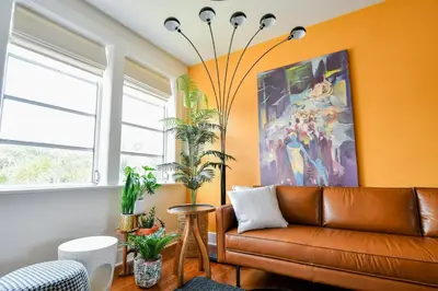 a living room with a brown leather couch and a painting at Stylish 2br apt, king-size bed, 5mins to the beach - J3 in Hollywood