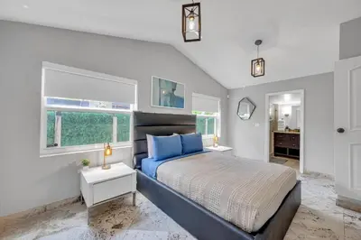 a bedroom with a large bed and two windows at Wonderful Tropical Pool House Miami South Brickell in Miami