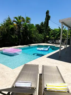 a swimming pool with two chaise lounges in front at Casita with pool, laundry and FREE parking in Miami