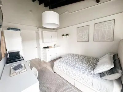 a small bedroom with a bed and a table at Casita with pool, laundry and FREE parking in Miami