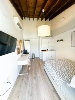 a bedroom with a bed and a desk and a television at Casita with pool, laundry and FREE parking in Miami