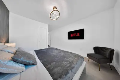 a bedroom with a bed with a chair and a clock at Luxury Villa Serena Heated Pool 15 min to Beach in Miami