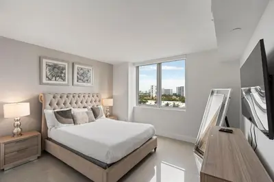 a white bedroom with a bed and a window at WATERFRONT Luxury 3 Bed 3 Bath Suite in Hallandale Beach
