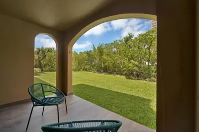 a patio with two chairs and a view of a yard at Apartamento Aventura 3 habitaciones in Aventura