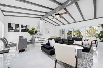 a living room with a ceiling fan and black furniture at Fort Lauderdale Water Front Oasis in Fort Lauderdale