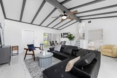 a living room with a black couch and a table at Fort Lauderdale Water Front Oasis in Fort Lauderdale
