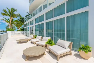a patio with chairs and tables on a building at Tiffany Topaz - Rooftop Pool, Gym, Walk to Beach in Fort Lauderdale