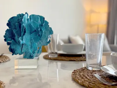 a table with two glasses and a blue flower on it at Tiffany Topaz - Rooftop Pool, Gym, Walk to Beach in Fort Lauderdale