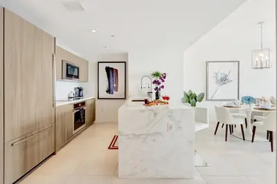 a kitchen and dining room with a marble counter at Tiffany Topaz - Rooftop Pool, Gym, Walk to Beach in Fort Lauderdale