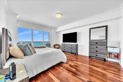 a bedroom with a bed and a dresser with a television at South City Suites in Hallandale Beach
