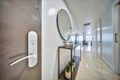 a hallway with a mirror and a table with a mirror at South City Suites in Hallandale Beach